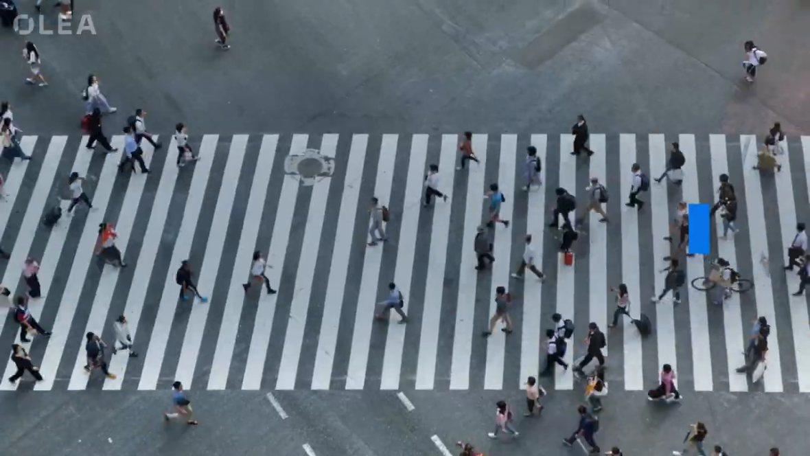 Group of people walking across a zebra crossing on a busy street