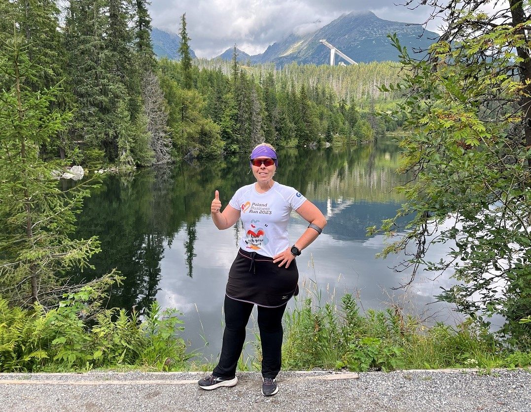 Standard Chartered Poland Business Run runner stands in front of the lake in Polish moutains